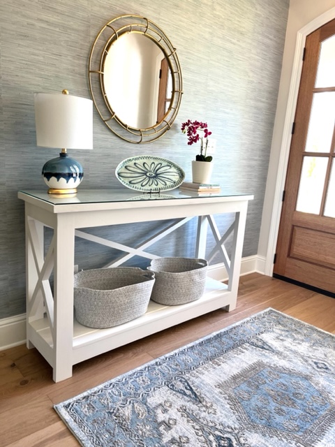 entryway with white console table and blue and silver rug