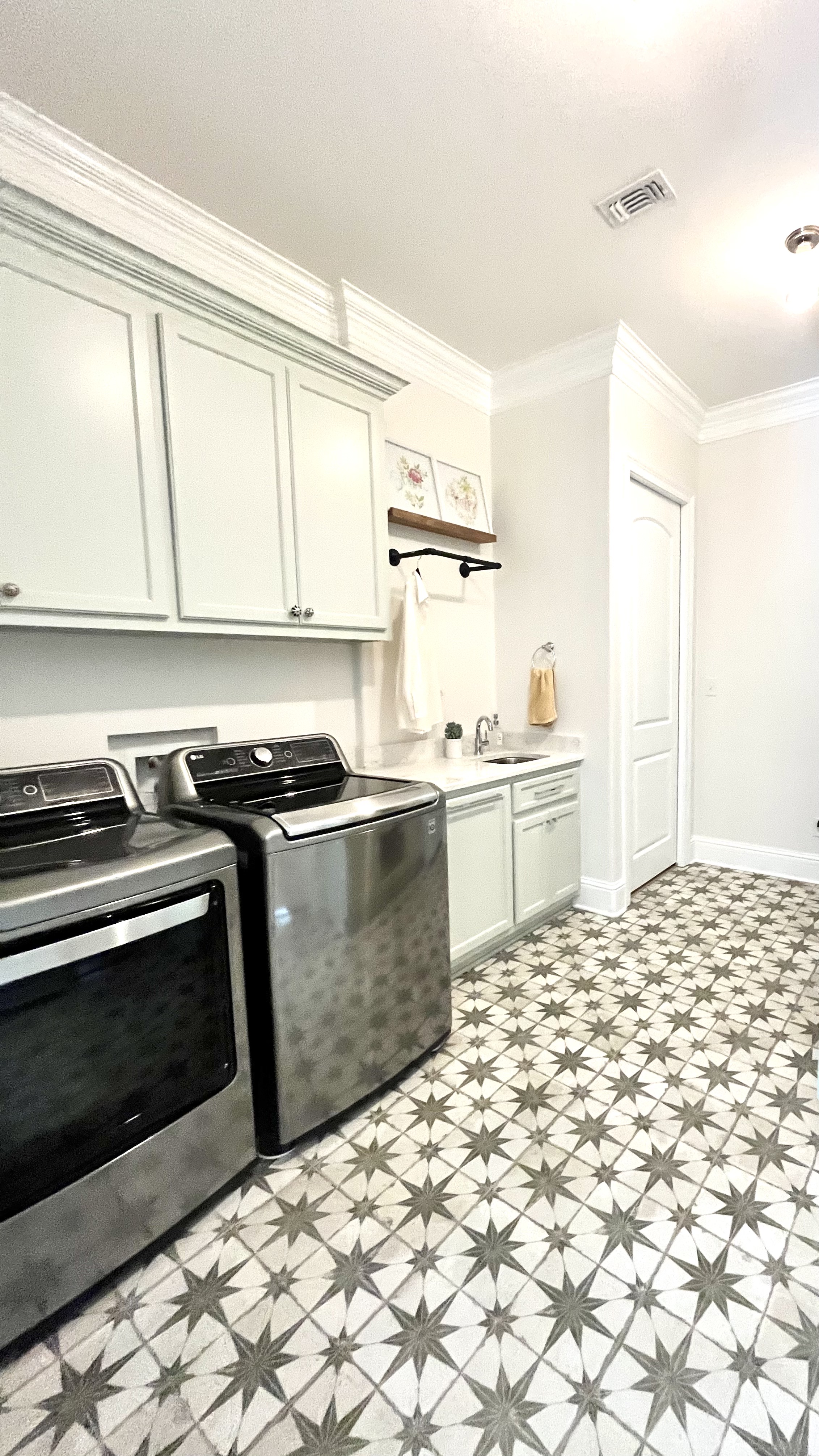 laundry room with light green cabinets and green star tiled floor