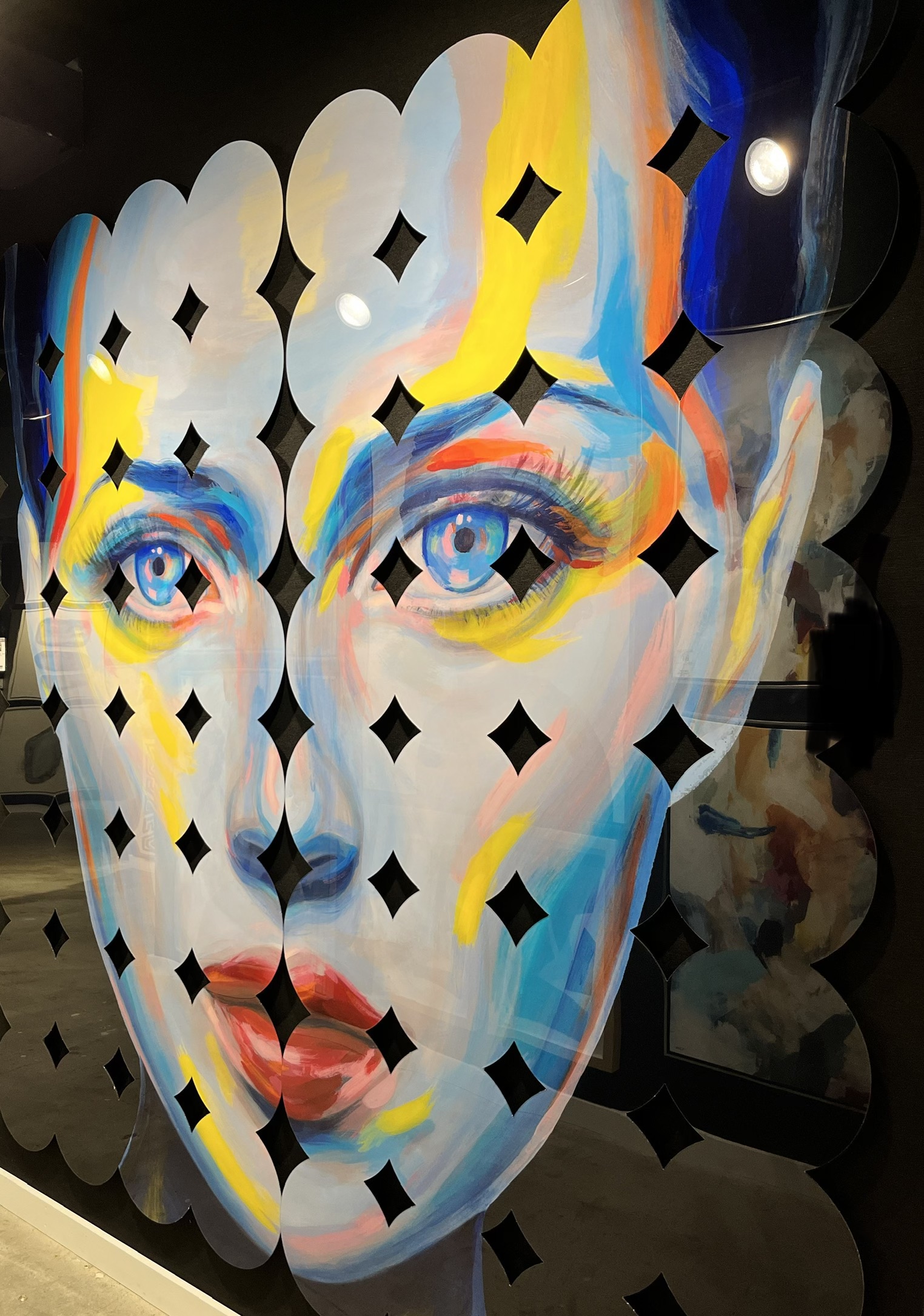 ladies face in bright bold primary colors with diamond cut outs all around it