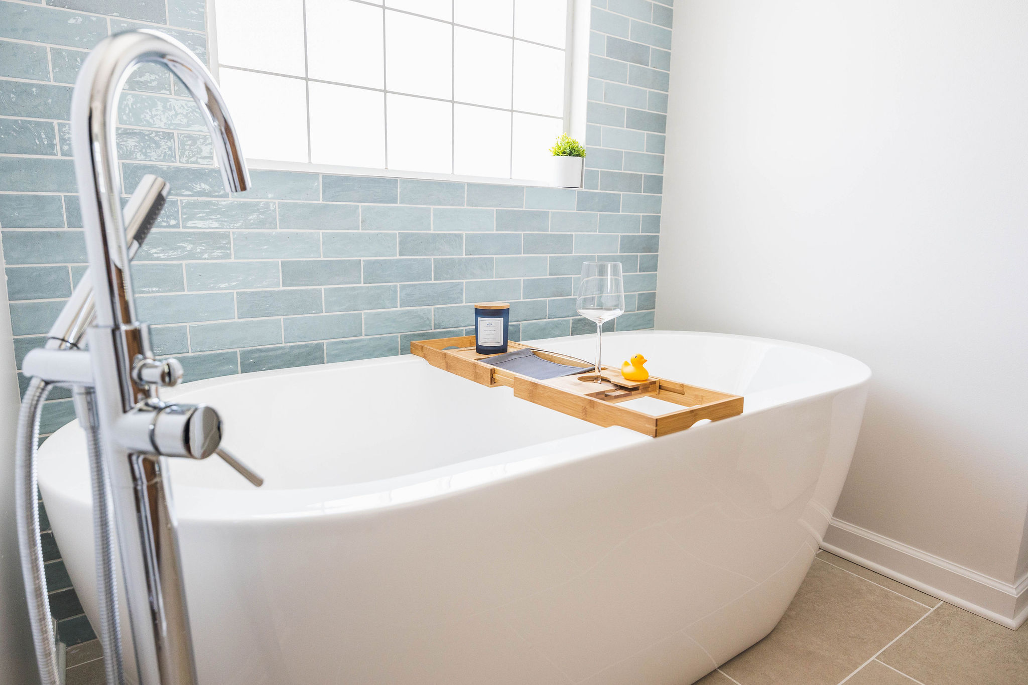 Freestanding tub with blue tile and chrome fixtures