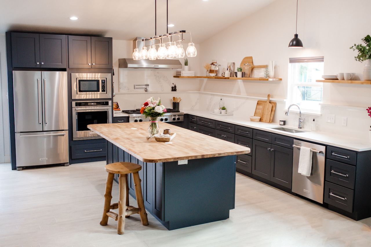 kitchen with dark grey cabinets, butcher block countertop, quartz countertop and black lighting