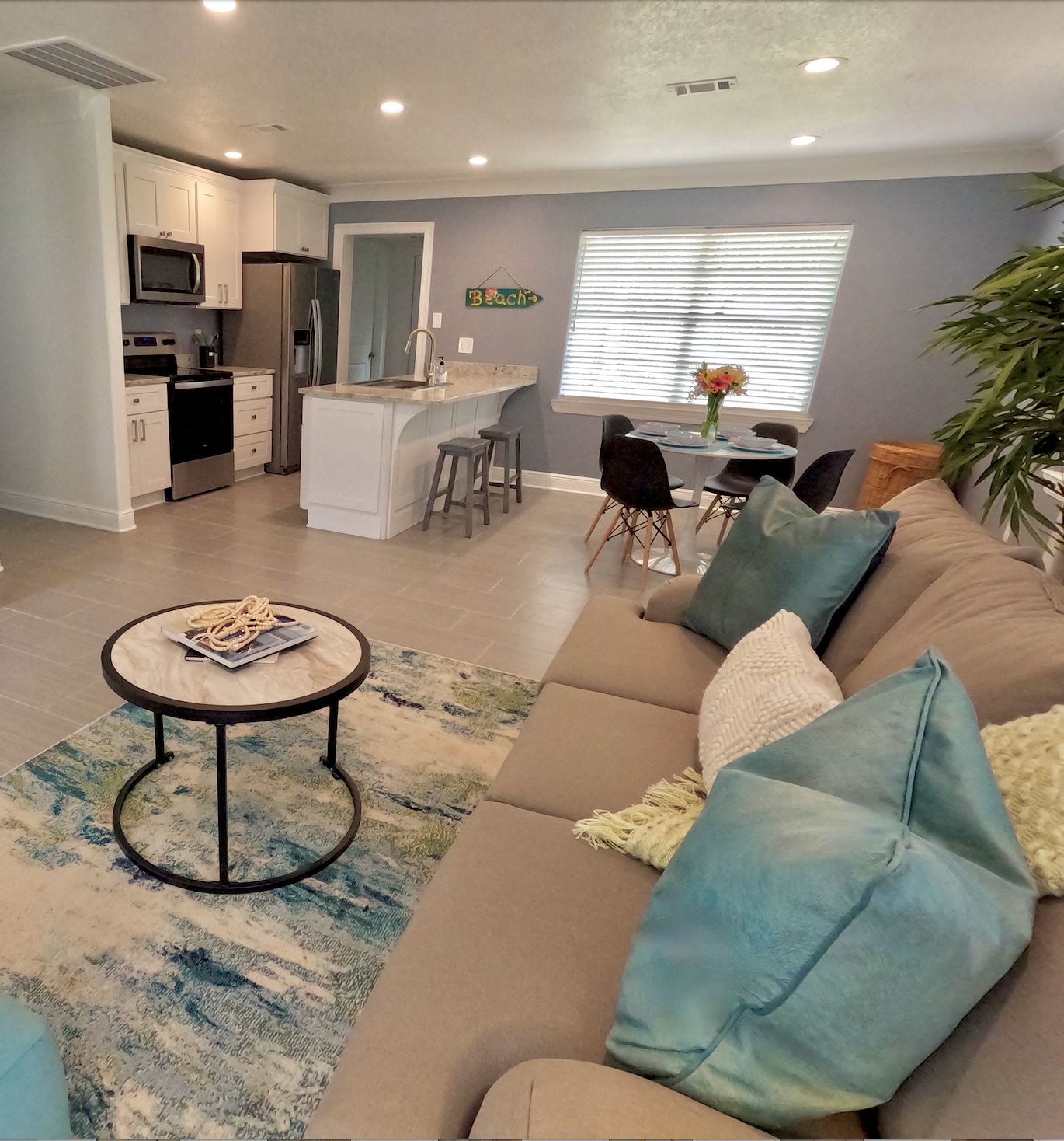 A coastal living room and kitchen with eat in dining area